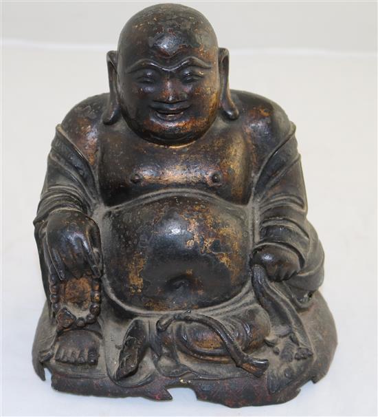 A Chinese gilt lacquered bronze seated figure of Budai, late Ming dynasty, 17cm, damage